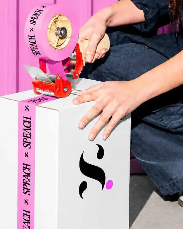 Manos sellando una caja blanca con cinta rosa de Speach
